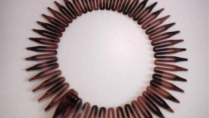 Ein brauner Haarreif liegt kreisf&ouml;rmig auf einem wei&szlig;en Tisch. Die Zacken sind gleichm&auml;&szlig;ig angeordnet.