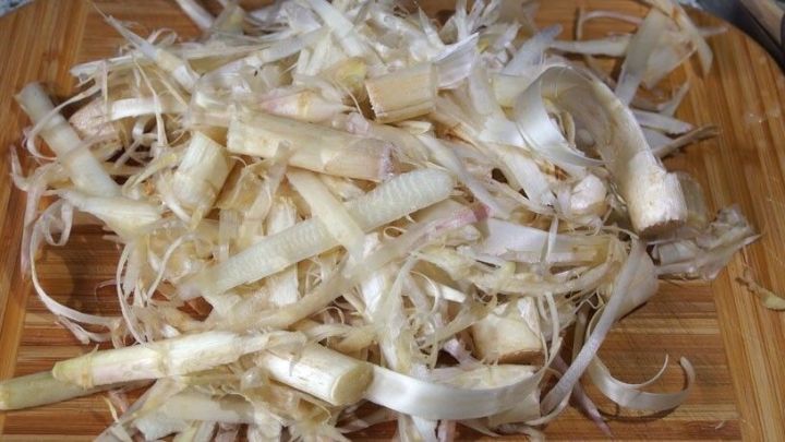 Eine Ansammlung von Spargelschalen liegt auf einem Holzbrett, bereit zur Weiterverwertung in der K&uuml;che.