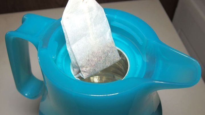 Eine t&uuml;rkisfarbene Thermoskanne mit einem Teebeutel, der im Innenraum zum Ziehen von Fencheltee genutzt wird.