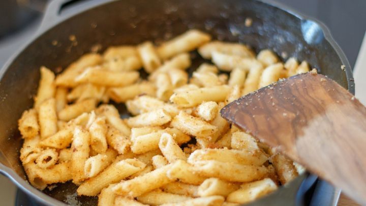 Zerkochte Nudeln werden in einer Pfanne goldbraun gebraten, um sie schmackhaft zu machen und mit anderen Zutaten zu kombinieren.