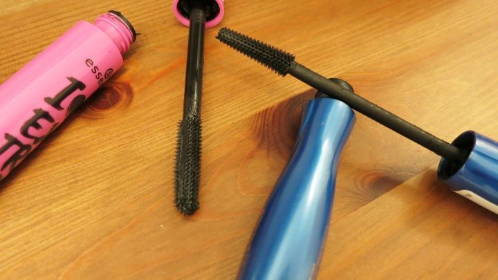 Zwei Mascara mit abgedichteten B&uuml;rsten liegen auf einem Tisch, w&auml;hrend ihre Verpackungen offen sind, um den Inhalt zu zeigen.