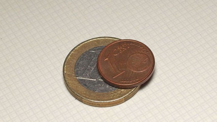 Zwei Euro-M&uuml;nzen liegen auf einer hellen Oberfl&auml;che, was die Frage aufwirft, ob Geld f&uuml;r den Einkaufswagen n&ouml;tig ist.