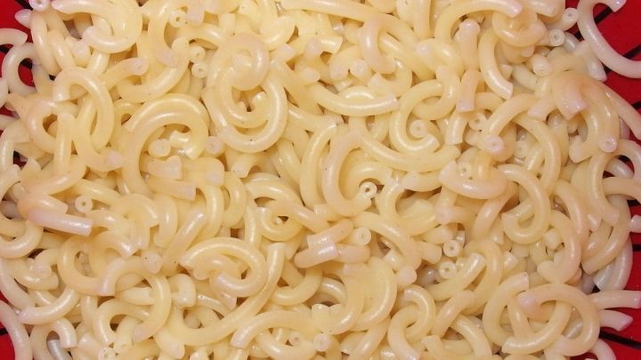 Leckere Gabelnudeln liegen ungeordnet in einer roten Sch&uuml;ssel, bereit zum Servieren oder Weiterverarbeiten.