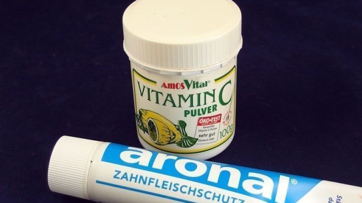Ein Beh&auml;lter mit Vitamin C-Pulver steht neben einer Zahnpasta, die f&uuml;r Zahnfleischschutz beworben wird.