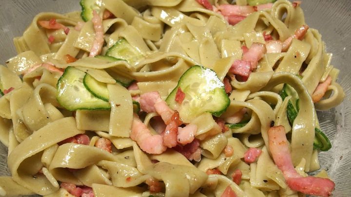 Ein bunter Nudelsalat mit Bandnudeln, Schinken und Zucchini, frisch zubereitet f&uuml;r einen sommerlichen Genuss.