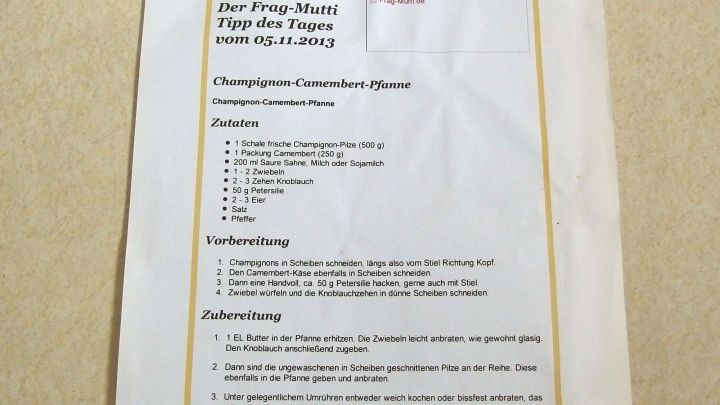 Rezepte sind auf ein Blatt Papier gedruckt, das an einen Schrank geklebt ist, um Kochanleitungen einfach erreichbar zu machen.