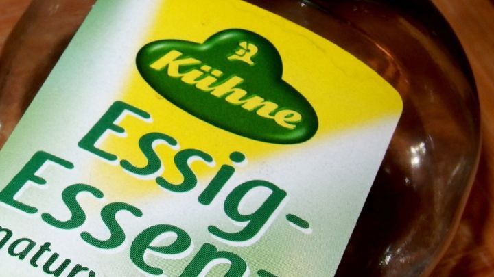 Eine Flasche Essig-Essenz steht auf einem Tisch, bereit zur WC-Reinigung unter dem Rand.