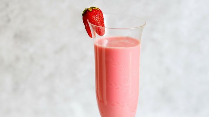 Ein Erdbeer-Schlamm-Bowle in einem eleganten Glas, umgeben von frischen Erdbeeren auf einem Tellerrand.