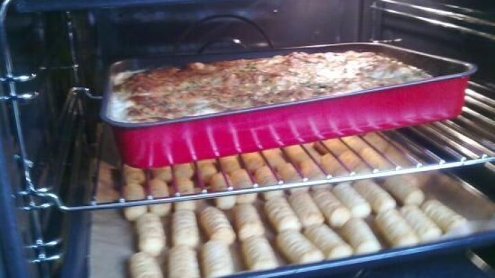 Im Ofen brutzelt ein H&auml;hnchenbrustfilet in einer Sahne-Knoblauch-Petersilie-So&szlig;e, w&auml;hrend daneben Gnocchi garen.