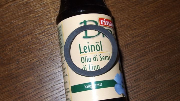 Eine Flasche Lein&ouml;l steht auf einem Holztisch, bereit, um Gummidichtungen zu pr&auml;parieren.