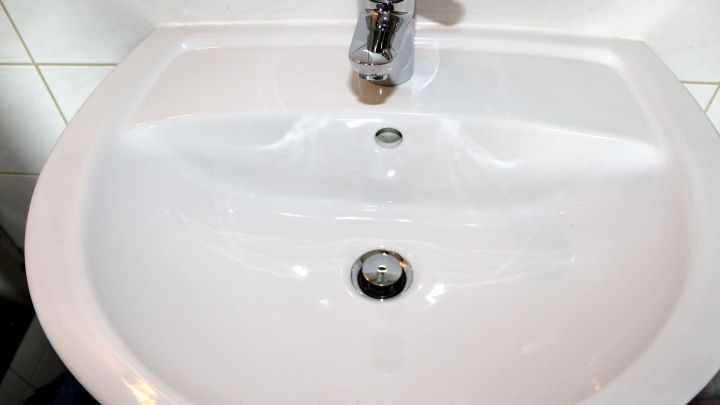 Ein Waschbecken mit einem klaren, wei&szlig;en Porzellanfinish, das keine sichtbaren Metallkratzer aufweist.