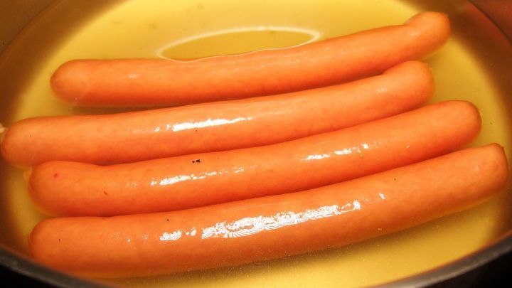 Wiener W&uuml;rstchen sind in einem Topf mit hei&szlig;em Wasser, um sie geschmackvoll warmzumachen. Ein einfacher Kochprozess.