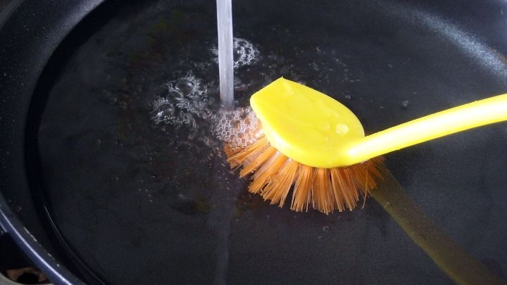 Eine Sp&uuml;lb&uuml;rste wird gerade in einem Waschbecken mit Wasser gereinigt, um ihre Pflege zu gew&auml;hrleisten.