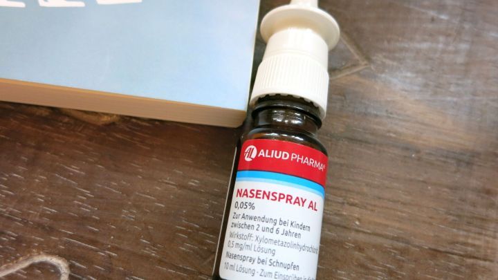 Eine Nasensprayflasche liegt auf einem Tisch, um Beschwerden wie Druck oder Ohrenschmerzen beim Fliegen zu lindern.