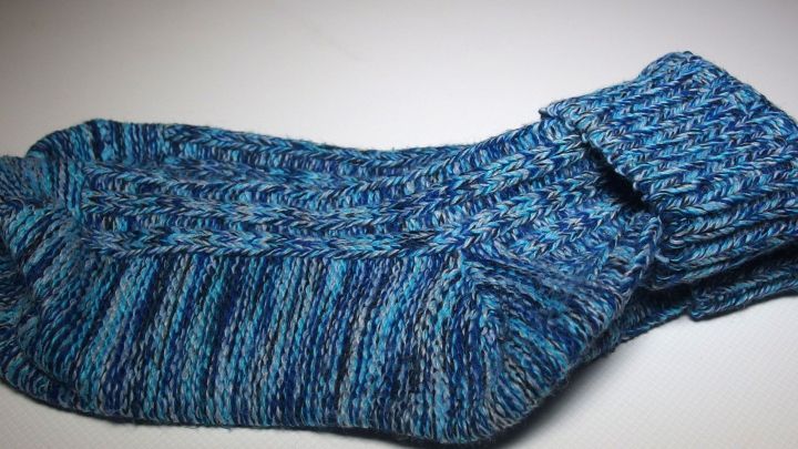 Wollsocken liegen zusammengelegt auf einem hellen Untergrund, bereit, die F&uuml;&szlig;e warm zu halten und Fu&szlig;pilz vorzubeugen.