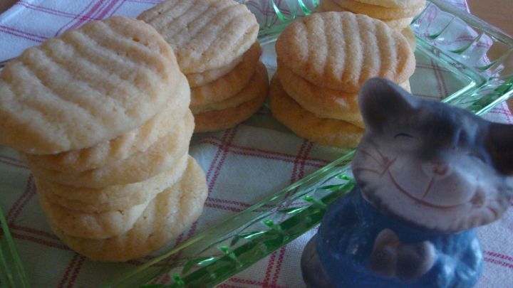 Butterkekse liegen ordentlich auf einem gr&uuml;nen Teller, w&auml;hrend eine kleine Figur daneben steht, die den Tisch dekoriert.