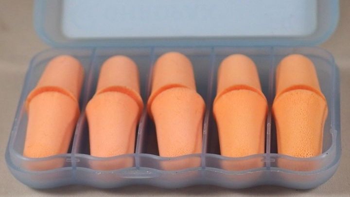 Eine transparente Box enth&auml;lt f&uuml;nf orangefarbene Ohrenst&ouml;psel, bereit zur Nutzung zum Schutz gegen Ohrenschmalz.