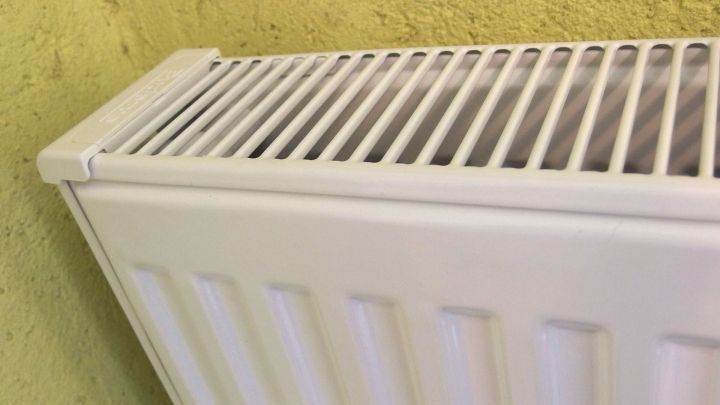 Ein Heizk&ouml;rper steht an einer gelben Wand. Er ist sauber und bereit f&uuml;r die Reinigung von Staub mit einem Dampfreiniger.