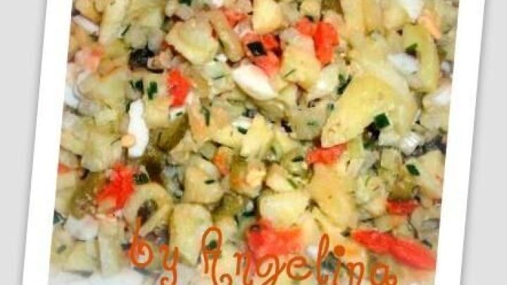 Kartoffelsalat mit Paprika und Kr&auml;utern liegt auf einem Teller. Im Bildtext steht: "by Angelina".