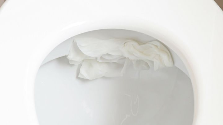 Ein Toilettenbecken mit einem Essigwickel, der in Wasser schwimmt, zur Bek&auml;mpfung von Kalkablagerungen.