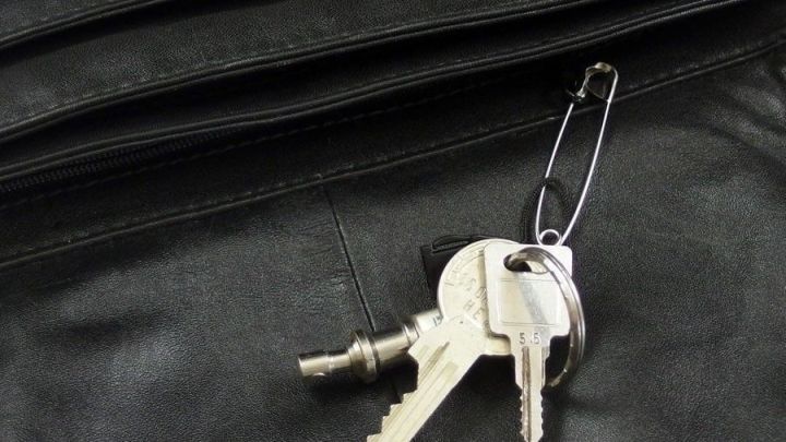 Ein Schl&uuml;sselbund liegt an einer Schwarzlederoberfl&auml;che, bereit zur Verwendung, um das Schl&uuml;sselsuchen in der Handtasche zu vermeiden.