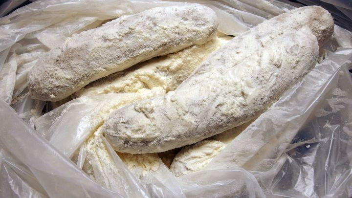 Bratw&uuml;rste liegen in einer durchsichtigen T&uuml;te, die mit Mehl best&auml;ubt sind, bereit zum Braten oder Grillen.