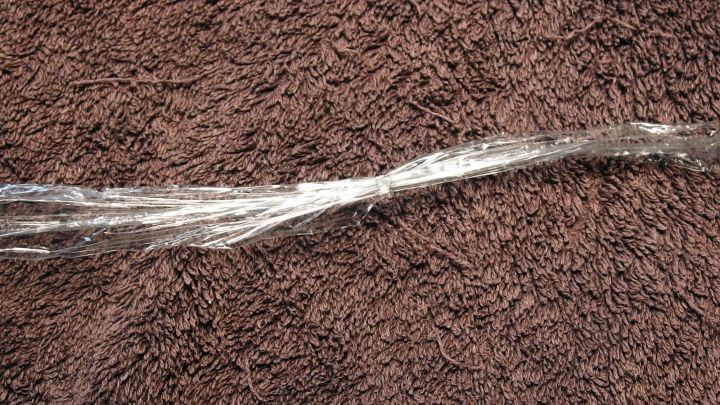 Ein transparenter Faden liegt auf einem braunen Tuch, bereit f&uuml;r die Nutzung als Zahnseide-Ersatz zur Zahnreinigung.