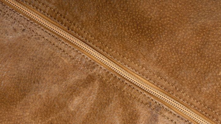 Eine Wildlederjacke in einem nahen Blickwinkel zeigt den Rei&szlig;verschluss und die strukturierte Oberfl&auml;che des Materials.