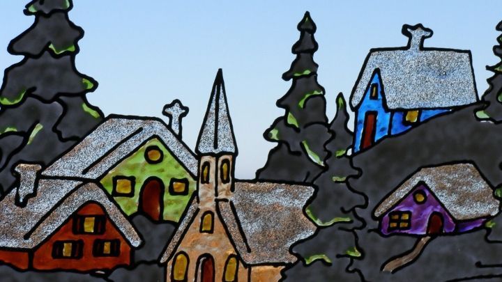 Window Color-Bild zeigt bunte H&uuml;tten und Kirche im Wald vor hellem Himmel, als Handwerkskunst gestaltet.