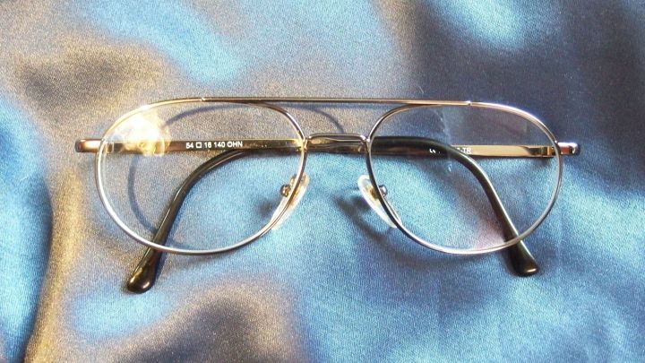 Eine Brille liegt auf einem blauen Stoff. Sie wird gereinigt, um klare Sicht zu gew&auml;hrleisten.