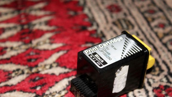 Ein Druckertintenpatrone liegt auf einem bunten Teppich. Sie zeigt die Aufschrift und ist bereit zur Verwendung.