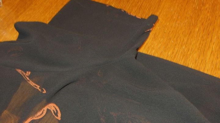 Ein schwarzes Kleidungsst&uuml;ck liegt auf einem hellen Holztisch, vielleicht zur Behandlung mit Citrusessenz gegen Schwei&szlig;geruch.