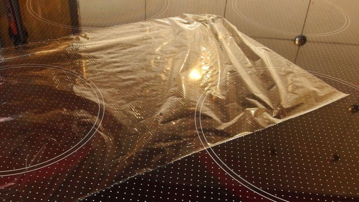 Ein St&uuml;ck Frischhaltefolie liegt auf einer glatten Oberfl&auml;che, bereit zum Abdecken von Lebensmitteln oder Geschirr.