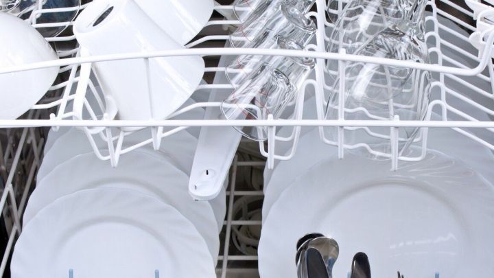 Saubere Teller, Gl&auml;ser und Besteck stehen geordnet im Geschirrsp&uuml;ler, bereit zum Klarsp&uuml;len mit Essig f&uuml;r optimalen Glanz.