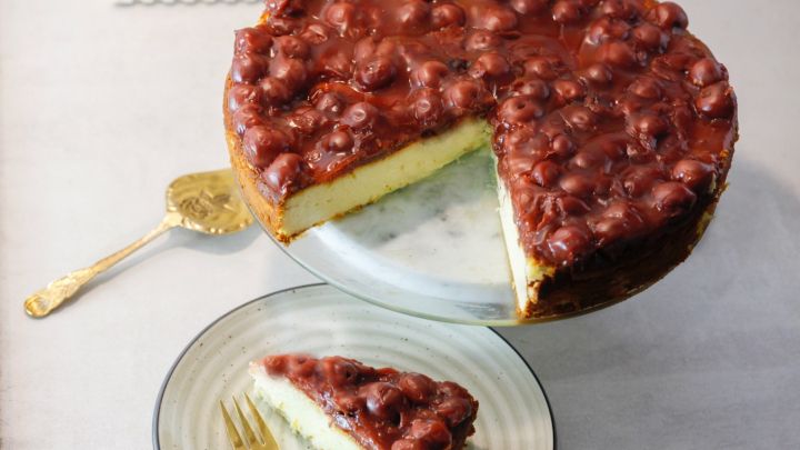 Zum Artikel K&auml;sekuchen ohne Boden mit Kirschen: Saftiger K&auml;sekuchen mit Kirschdecke, ein St&uuml;ck schon serviert.