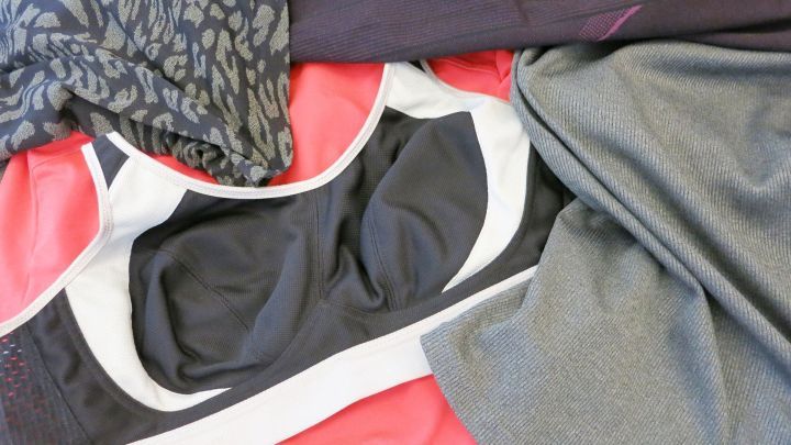 Sportkleidung liegt &uuml;bereinander und zeigt Schwei&szlig;flecken, was unangenehme Ger&uuml;che symbolisiert.