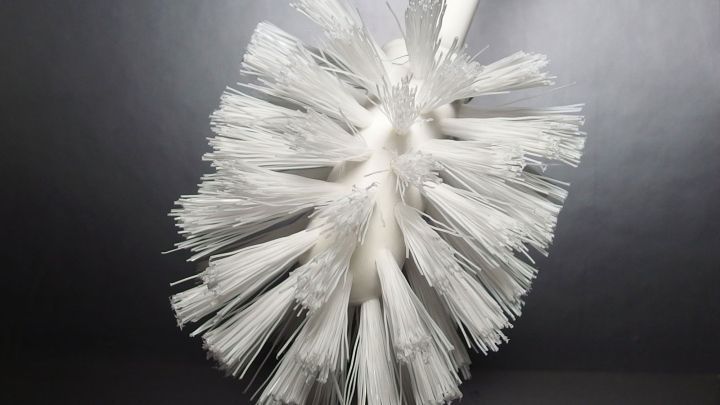 Eine Klosch&uuml;sselb&uuml;rste steht auf einem dunklen Hintergrund und wartet darauf, zum Reinigen einer Toilette verwendet zu werden.