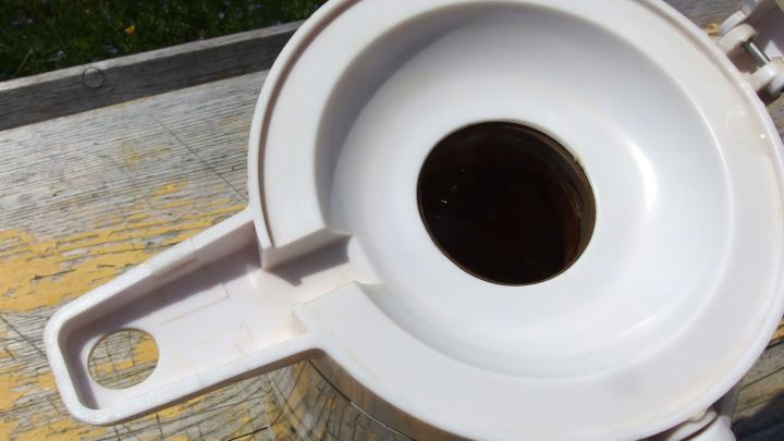 Eine Thermoskanne mit Edelstahlseife wird verwendet, um unerw&uuml;nschte Ger&uuml;che zu beseitigen. Sie steht auf einer Holzoberfl&auml;che.