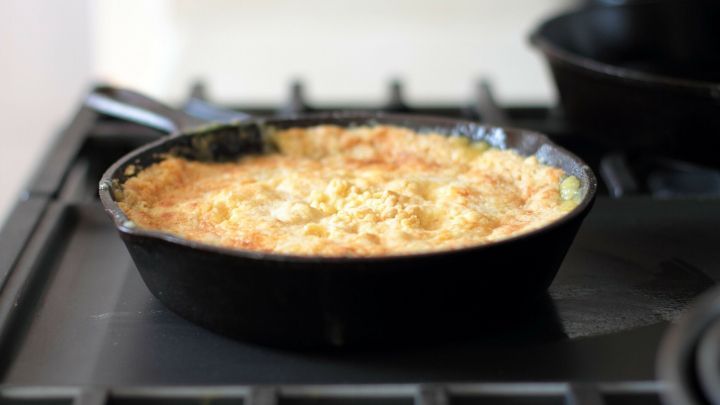 Ein frisch gebackener herzafter Cobbler in einer Gusseisenpfanne ruht auf einem Herd, bereit zum Servieren.