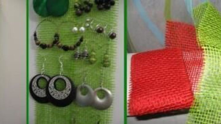 Ohrringe h&auml;ngen an einem gr&uuml;nen Netz an der Wand, darauf diverse Schmuckst&uuml;cke; daneben Farbvarianten des Netzes in Rot und Wei&szlig;.