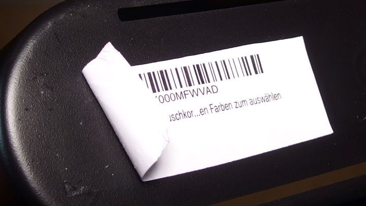 Ein beklebter Gegenstand mit abstehenden Kanten wird mit Bremsreiniger behandelt, um die Klebereste zu entfernen.