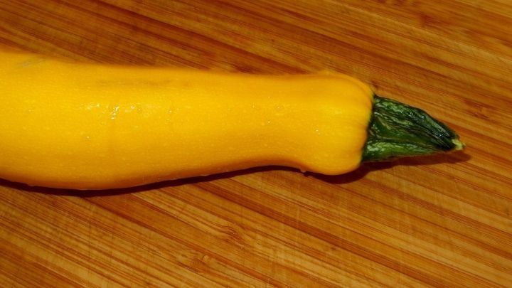 Eine gelbe Zucchini liegt auf einem Holzbrett, bereit zur Verarbeitung in verschiedenen Gerichten oder Rezepten.
