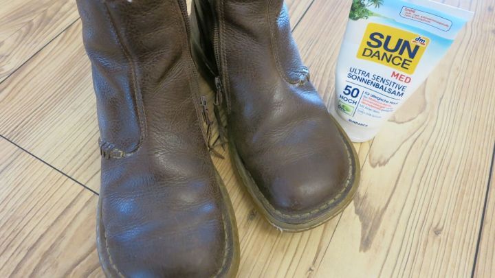 Braune Lederschuhe stehen auf Holzboden, neben ihnen befindet sich eine Tube "SUN DANCE MED ULTRA SENSITIVE SONNENBALSAM 50 HOCH".