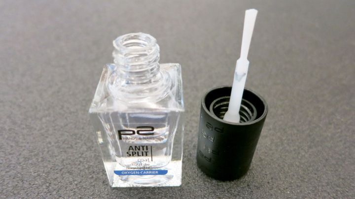 Ein transparenter Nagellack steht ge&ouml;ffnet auf einer grauen Oberfl&auml;che, bereit zur Anwendung gegen M&uuml;ckenstiche.