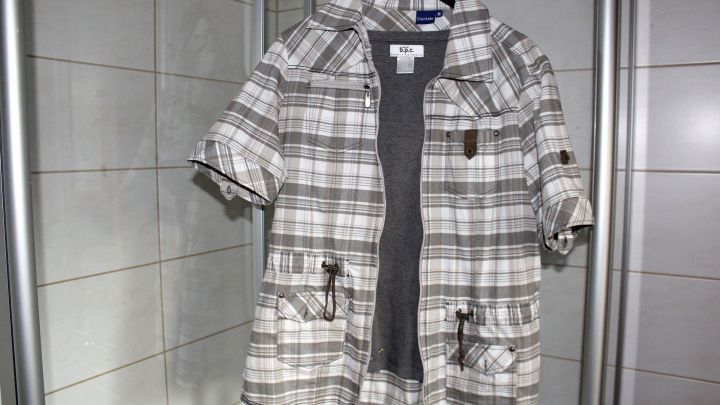 Eine kariert H&auml;ngemantel h&auml;ngt an einem Haken in einem Badezimmer, bereit, nach dem Waschen &bdquo;schleudertrocken&ldquo; zu werden.