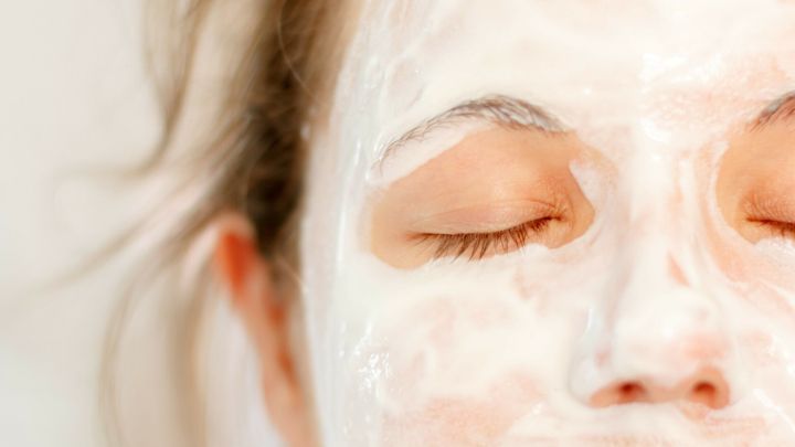 Eine Person mit einem Gesichtswaschmittel gegen Pickel tr&auml;gt eine Maske auf, w&auml;hrend sie entspannt dasteht.