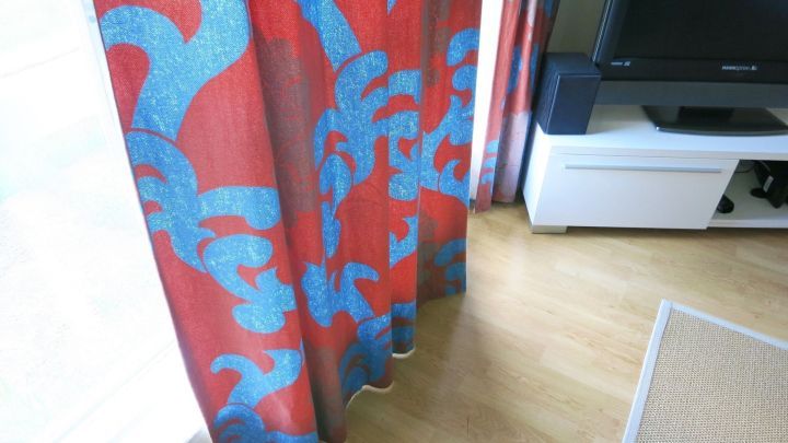 Bunte Gardinen h&auml;ngen und sch&uuml;tzen den Raum vor Sonnenlicht, w&auml;hrend sie elegant den Wohnbereich versch&ouml;nern.