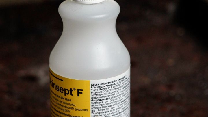 Eine Flasche Hautdesinfektionsmittel steht auf einer Oberfl&auml;che neben Wattepads, bereit zur Anwendung gegen Fu&szlig;pilz.