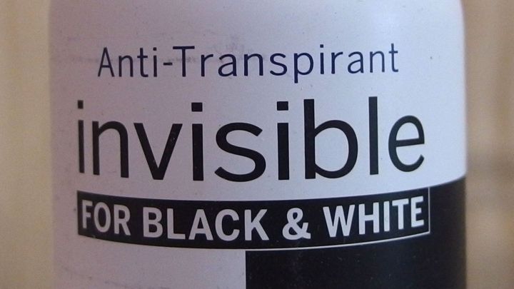 Eine Antitranspirant-Flasche steht im Fokus, mit der Aufschrift "Anti-Transpirant invisible FOR BLACK & WHITE", die l&auml;stiges Schwitzen bek&auml;mpft.
