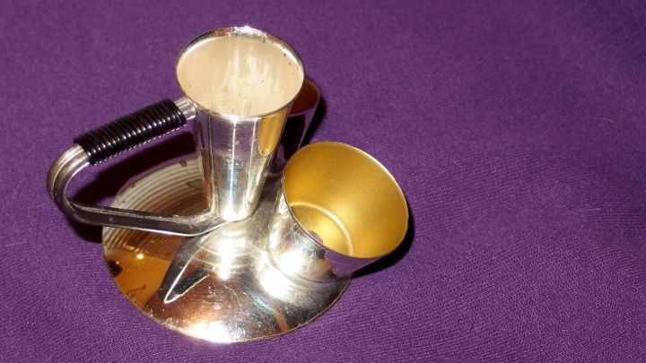 Ein eleganter Kerzenleuchter steht auf einem lila Stoff, w&auml;hrend er auf die Reinigung vorbereitet wird.